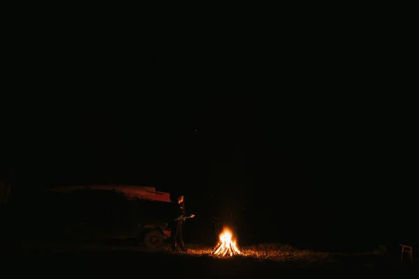 夜林中篝火边坐着取暖的女人. — 图库照片