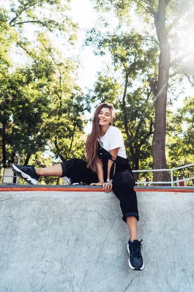 Bella ragazza hipster seduta sul bordo di una rampa — Foto Stock