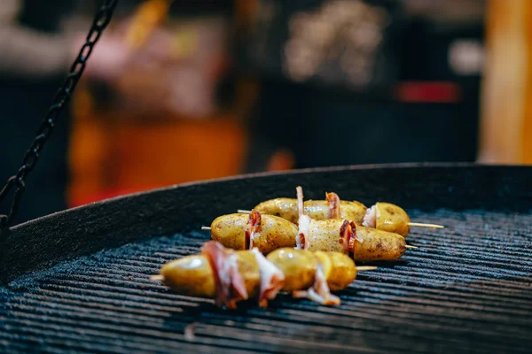 Batata com bacon em espetos cozidos na fogueira — Fotografia de Stock
