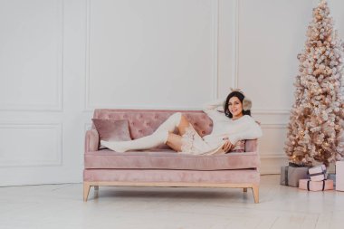 Güzel kadın kanepede yatıyor.