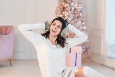 Noel ağacının yanında zarif elbiseli genç bir kadın.