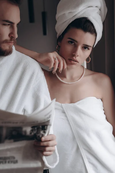 Парень в белом халате и девушка в полотенце — стоковое фото