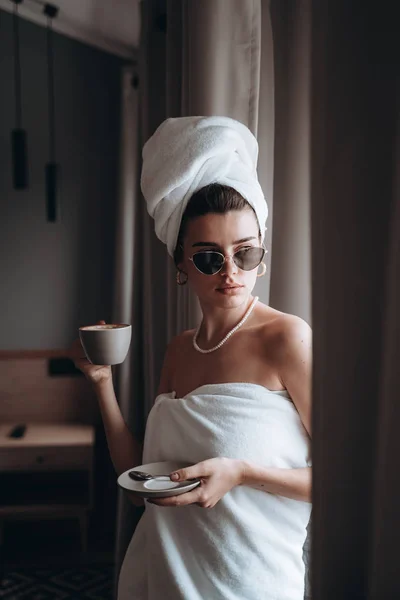 Menina envolto em uma toalha beber café — Fotografia de Stock