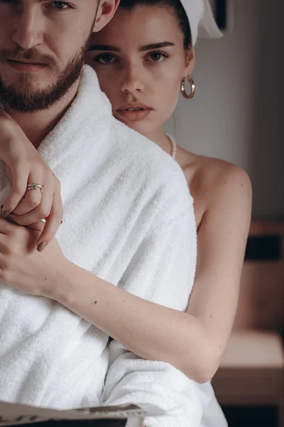 Guy in a white coat and a girl in a towel — Stock Photo, Image