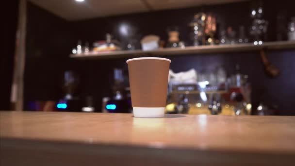 Papier Cup op rustieke houten tafel en wonman hand neemt het weg — Stockvideo