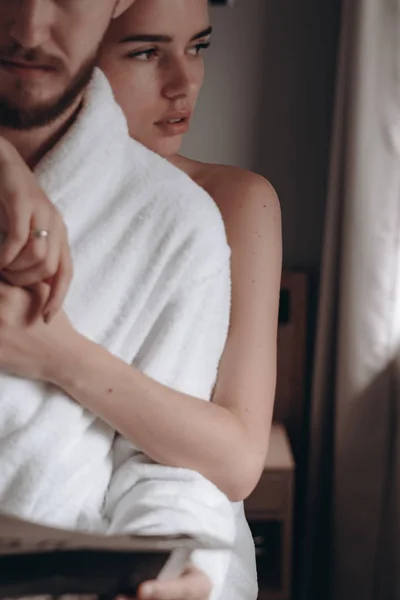 Парень в белом халате и девушка в полотенце — стоковое фото