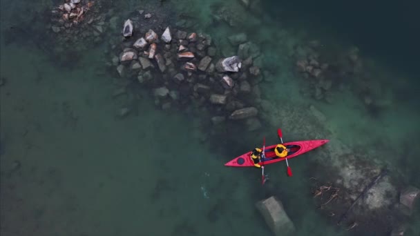 Two athletic man floats on a red boat in river — Stock Video