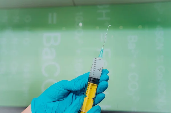 Las manos en guantes de goma sostienen una jeringa médica desechable con el medicamento —  Fotos de Stock