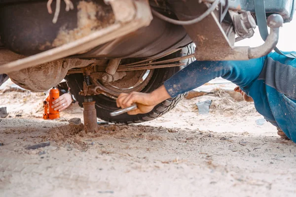 Un hombre levanta en un jack 4x4 fuera del camión de carretera — Foto de Stock