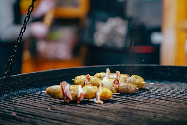 Pommes de terre avec bacon sur brochettes cuites sur le bûcher — Photo