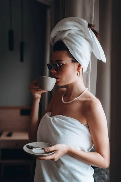 Chica envuelta en una toalla después de una ducha tomando café — Foto de Stock
