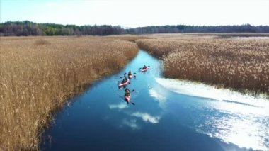 Bir grup insan kayaks sazlık sonbahar Nehri üzerinde arasında.