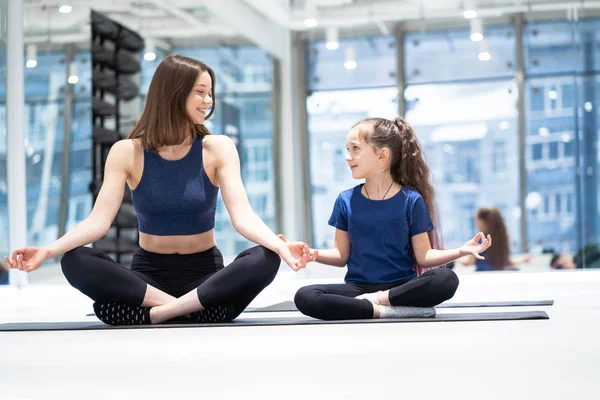 Genç yetişkin anne ve küçük kızı birlikte yoga yapıyorlar. — Stok fotoğraf