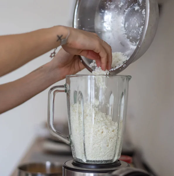 Mulher derramando queijo cottage em um liquidificador na cozinha — Fotografia de Stock