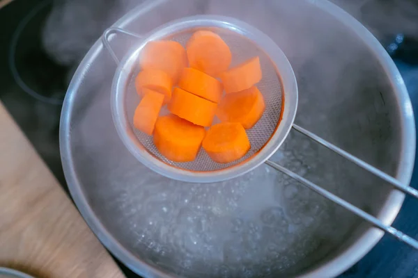 The image of a small amount of chopped carrots over a boiling pan — Stock Photo, Image