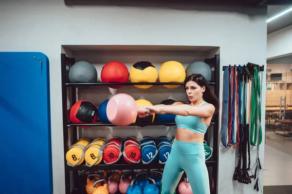 Joven chica adulta haciendo ejercicios de fuerza en el gimnasio —  Fotos de Stock