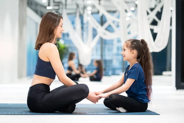 Genç yetişkin anne ve küçük kızı birlikte yoga yapıyorlar. — Stok fotoğraf