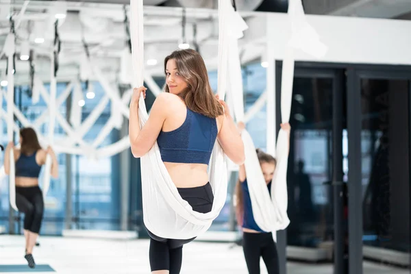 Vlieg yoga. Jonge vrouw oefent luchtfoto anti-zwaartekracht yoga — Stockfoto