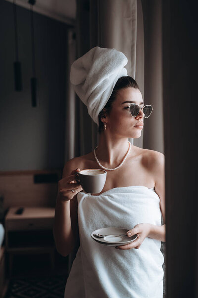 Girl wrapped in a towel drinking coffee — Stock Photo, Image