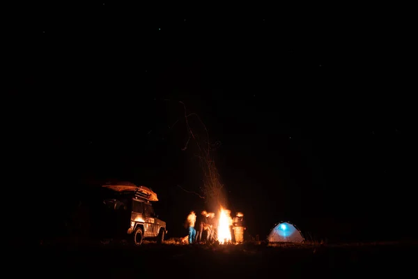 Amis heureux se reposer ensemble autour du feu de camp — Photo