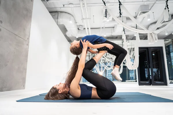 Jong volwassen moeder doet fitness met haar kleine dochter — Stockfoto
