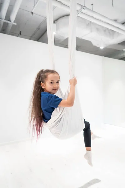 Potret seorang gadis muda yang cantik terlibat dalam yoga terbang di kanvas. — Stok Foto