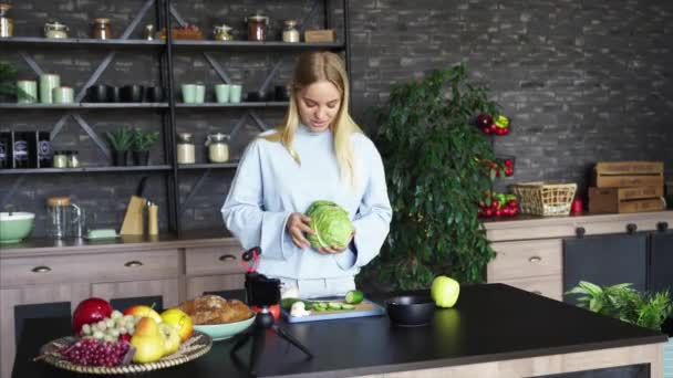 Joven hermosa rubia toma videos como ella cocina en la cocina — Vídeos de Stock