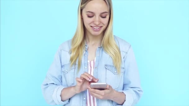 Imagen de la joven feliz de pie aislada sobre fondo azul . — Vídeo de stock