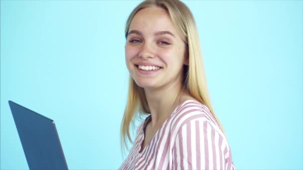 Obraz šťastné mladé dámy stojící izolovaně na modrém pozadí. — Stock video