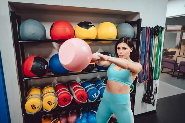 Joven chica adulta haciendo ejercicios de fuerza en el gimnasio —  Fotos de Stock