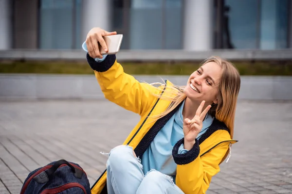 Menina bonita leva selfie no smartphone e senta-se no skate . — Fotografia de Stock