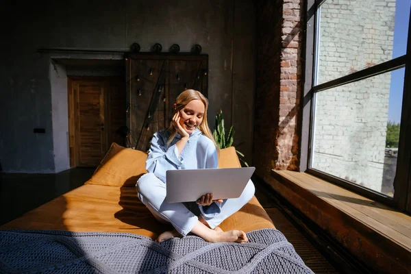 Sorridente donna attraente sdraiata sul letto utilizzando il computer portatile — Foto Stock