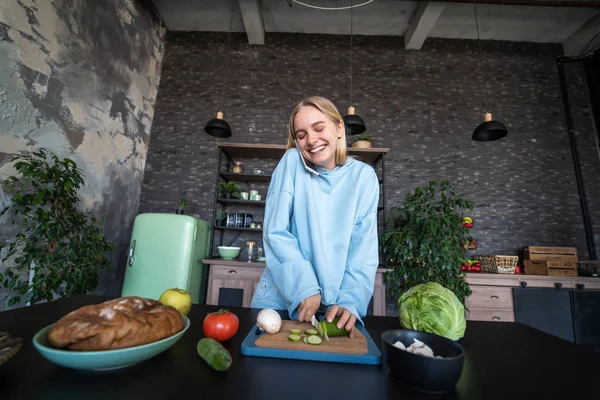 stock image Beautiful girl talking on the mobile phone in kitchen at home