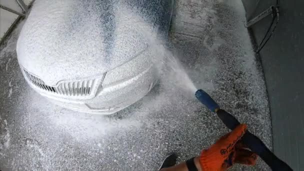 Jeune homme couvert de mousse de savon sur sa voiture — Video
