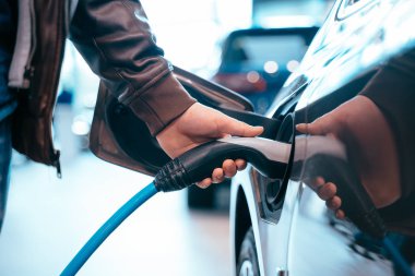 İnsan eli elektrik araba şarj elektrikli araba bağlamak tutuyor