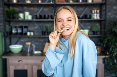 Güzel genç kız mutfakta poz veriyor.