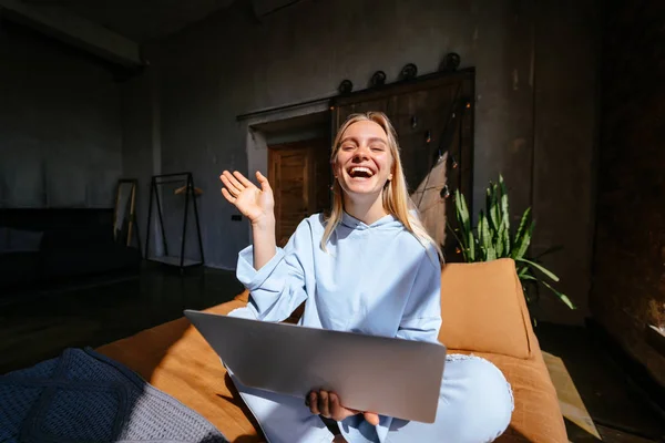 Gülümseyen çekici kadın yatakta laptop kullanarak yatıyor