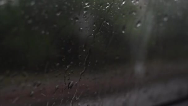 Gota de lluvia sobre el vidrio del coche en las imágenes del tráfico . — Vídeo de stock