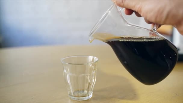 Barista häller kaffe i en glas mugg — Stockvideo