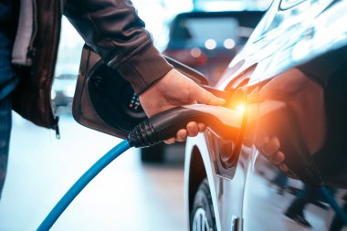 İnsan eli elektrik araba şarj elektrikli araba bağlamak tutuyor