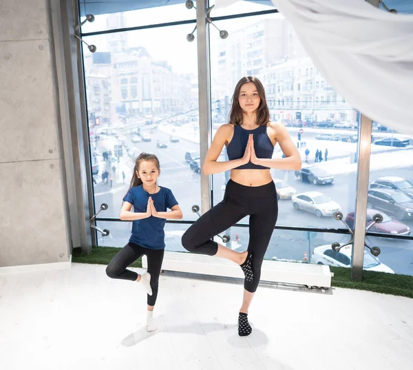 Jeune mère adulte et petite fille ensemble pratiquant le yoga — Photo