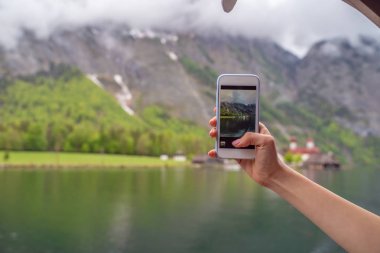 Turist Lake Hallstatter kendi akıllı telefon tarafından fotoğraf çekim noktası almaya çalışın