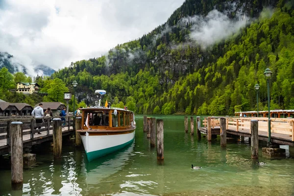 Scénický pohled na jezero Konigssee s dřevěným molem s zakotvenou turistickou lodí — Stock fotografie