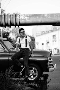 Retro arabada poz veren askılı gömlekli adam