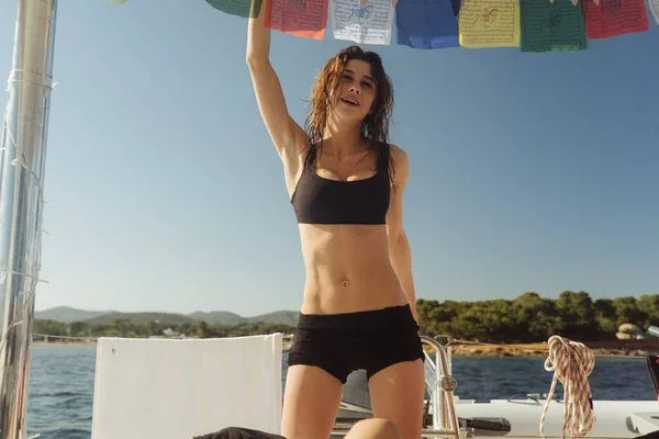 Ung sexig atletisk tjej i toppen och shorts på en yacht — Stockfoto