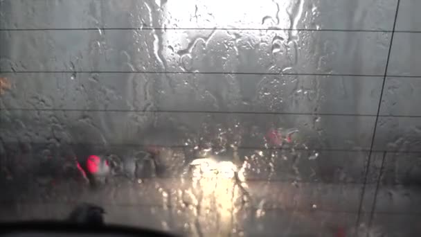 Gota de lluvia sobre el vidrio del coche en las imágenes del tráfico . — Vídeo de stock