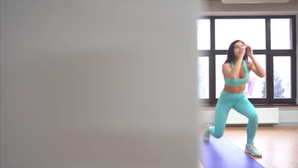 Молодая взрослая девушка делает упражнения в спортзале — стоковое видео
