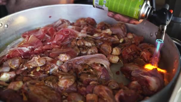 Un hombre con una antorcha quema la superficie de la carne — Vídeos de Stock