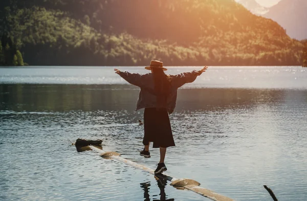 Flickan i klänning och hatt av sjön i bergen — Stockfoto