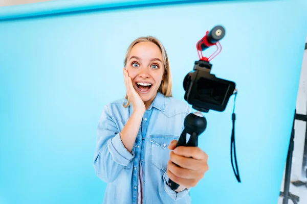 Menina bonita blogger alivia-se na câmera isolado fundo azul — Fotografia de Stock